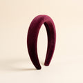Padded Velvet Headband in deep burgundy standing upright on an ivory background