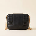 Quilted Chain Crossbody Bag in black channel-quilted faux leather with a chunky gold-tone chain strap on an ivory background